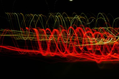 Dijital ışıkların hızı. Parlak kırmızı ve beyaz neon bir yörünge boyunca hızla hareket eden ışık akışları. Flaşlı hızlı enerji dalgaları. Siyah arkaplanda girdap izi.