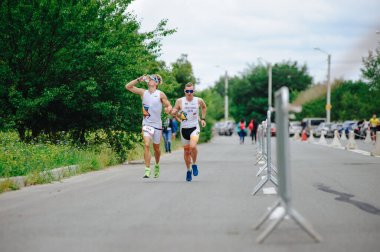 KHARKIV, UKRAINE - 2 AĞUSTOS 2020 Kharkiv triatlon Demir Yolu. Bisiklete geçtikten sonra koşan adam. Triatlon takımında koşan triatloncu Demir Adam yarışı için antrenman yapıyor.. 
