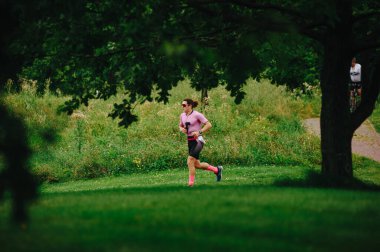 KHARKIV, UKRAINE - 2 AĞUSTOS 2020 Kharkiv triatlon Demir Yolu. Bisiklete geçtikten sonra koşan adam. Triatlon takımında koşan triatloncu Demir Adam yarışı için antrenman yapıyor.. 