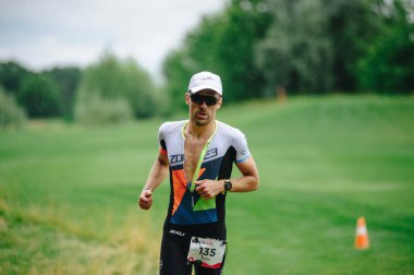 KHARKIV, UKRAINE - 2 AĞUSTOS 2020 Kharkiv triatlon Demir Yolu. Bisiklete geçtikten sonra koşan adam. Triatlon takımında koşan triatloncu Demir Adam yarışı için antrenman yapıyor.. 