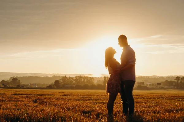 ロマンチックな関係の概念 小麦畑の明るい夕日の中を走っているカップル — ストック写真
