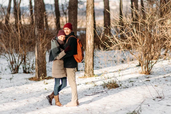 雪の冬に一緒にクリスマス休暇を過ごす幸せな愛情のカップル歩く 若いヒップスターカップルが冬の公園で抱き合っています 冬の愛の物語 美しいスタイリッシュな若いカップル — ストック写真
