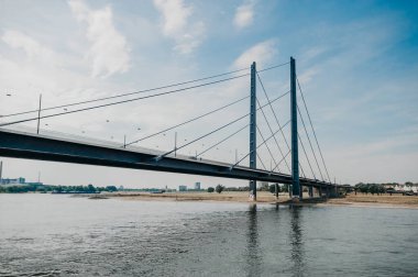 DÜKSELDORF, GERMANY - 13 AĞUSTOS 2020: Rheinkniebrcke, Dusseldorf 'taki Ren Nehri üzerinde 16 Ekim 1969' da trafiğe açılan kablo destekli bir köprü..