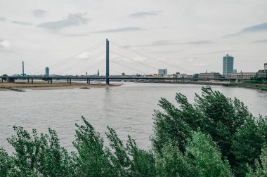 DÜKSELDORF, GERMANY - 13 AĞUSTOS 2020: Rheinkniebrcke, Dusseldorf 'taki Ren Nehri üzerinde 16 Ekim 1969' da trafiğe açılan kablo destekli bir köprü..