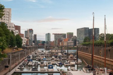 ALMANY, DUESSELDORF - 14 Ağustos 2020: günbatımında Medienhafen 'de tekneler. Medya limanında manzaralı Düsseldorf şehir manzarası