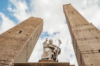 BOLOGNA, İtalya - 30 EYLÜL 2019: Torre Garisenda ve Torre Degli Asinelli 'nin Torri' deki kuleleri. Yani iki kule. Heykel De Hl. Petronius.