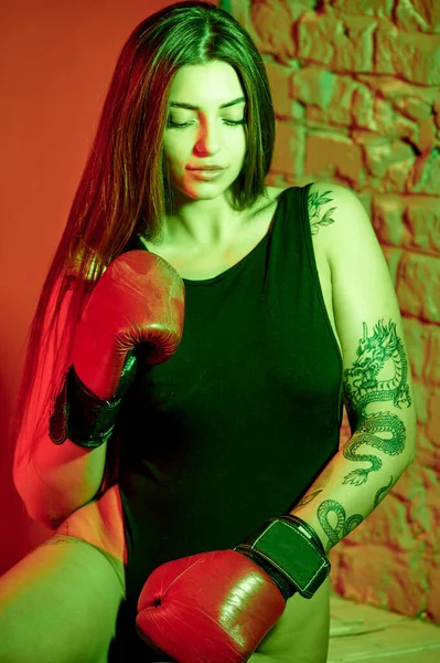 漂亮的女人 戴着红色拳击手套 回头看 坐在地板上 力量和动机 拳击和健身风格 — 图库照片