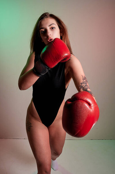 Красивая женщина в красных боксерских перчатках. Сила и мотивация. Бокс и фитнес стиль.