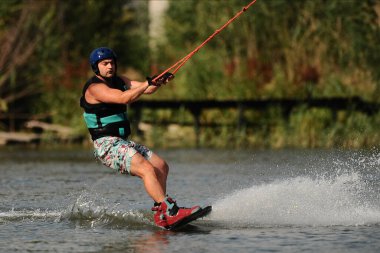 KHARKIV, UKRAINE - 31 Temmuz 2021: Ukrayna Şampiyonası. Wakeboardcu Kharkiv 'deki wakeboard etkinliğinde numaralar ve beceriler gösteriyor.