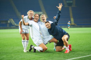 KHARKIV, UKRAINE - SEPTEMBER 9, 2021: Yuliia Shevchuk, Daryna Apanaschenko, Olha Ovdiychuk ve Dmytro Ponomarenko play-off galibiyetini kutluyorlar. UEFA Kadınlar Ligi Zhilstroi-1 - Apollon maçı.. 
