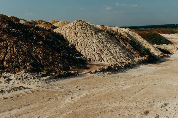 Sand quarry. Surface mine with exposed colored minerals at the bottom the pit.