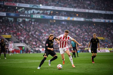 COLOGNE, Almanya - 18 Ekim 2025: Kristijan Jakiç, Marius Buelter - Bundesliga 1 'in futbol maçı. FC Koeln, FC Augsburg 'a karşı Rhein Enerji Stadyumu' nda.