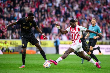 COLOGNE, GERMANY - 18 Ekim 2025: Chrikilled Matsima, Ragnar Ache - Bundesliga 1 'in futbol maçı. FC Koeln, FC Augsburg 'a karşı Rhein Enerji Stadyumu' nda.