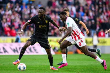 COLOGNE, GERMANY - 18 Ekim 2025: Chrikilled Matsima, Ragnar Ache - Bundesliga 1 'in futbol maçı. FC Koeln, FC Augsburg 'a karşı Rhein Enerji Stadyumu' nda.