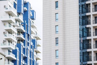 Balkonları olan modern apartmanlar. Mavi ve beyaz cepheli ve bir sürü balkonlu şehir mimarisi. Çağdaş konut ve şehir hayatı.