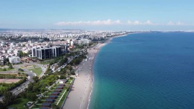 Antalya kıyı şeridinin hava panoramik manzarası, uzun kumlu sahili, turkuvaz Akdeniz 'i ve açık yaz gökyüzü altında yayılan şehir manzarasını gösteriyor. Notlandırılmamış, Dlog