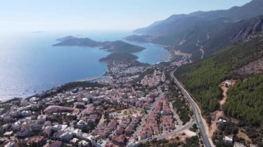Kızıl çatıları, dolambaçlı yolu, turkuaz Akdeniz ve çevresindeki dağlarla Kas şehrinin hava panoramik manzarası. Notlandırılmamış, Dlog