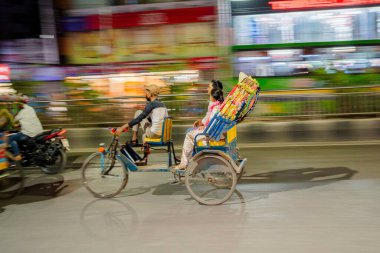 Geceleri renkli renkli bir triportörün hareket bulanıklığı. Renkli, süslü bir elektrikli triportör gece şehir trafiğinde hareket ediyor. Bu resim Güney Asya 'da bulunan eşsiz halk sanatını ve geleneksel ulaşımı yansıtıyor..
