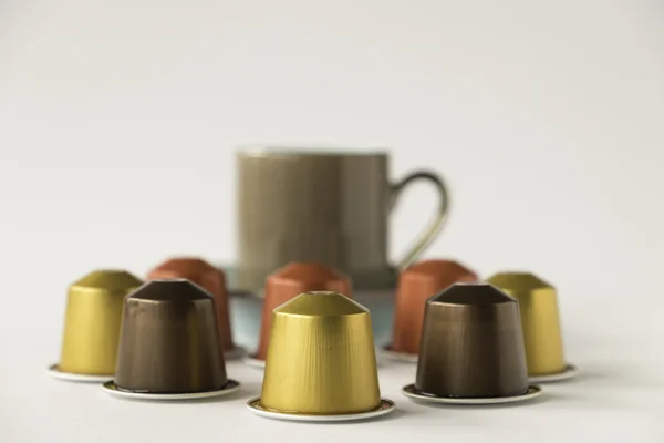 Coffee pods with espresso cup on white background
