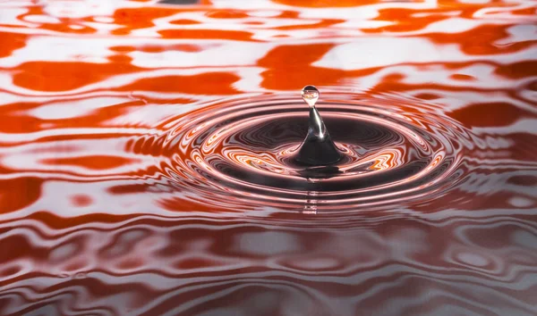 オレンジ色の ripppled の背景に水滴 — ストック写真