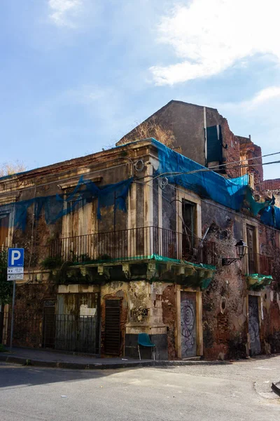 İki katlı derisi soyulmuş alçı, yıpranmış taş, balkon ve duvar yazısıyla ıssız bir bina. Terk edilme ve şehir keşfi temaları için ideal bir atmosferik kentsel yıkıntı bozunma, bozulma, doku ve tarih..