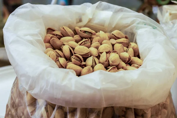 Temiz bir torba içindeki çok sayıdaki fıstığın yakın görüntüsü, dokularını ve mutfaklarının kullanılabilirliğini vurguluyor. Doğal atıştırmalıkları ya da sağlıklı yiyecek seçeneklerini göstermek için mükemmel..