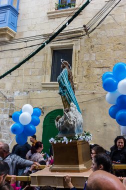 Cospicua, Malta - 1 Aralık 2024. Etrafı Bayraklar ve Balonlarla çevrili Bir Heykel Gösterisi