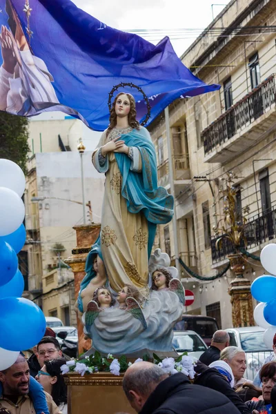Cospicua, Malta - 1 Aralık 2024. Etrafı Bayraklar ve Balonlarla çevrili Bir Heykel Gösterisi
