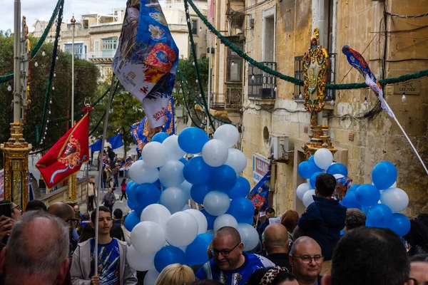 Cospicua, Malta - 1 Aralık 2024. Etrafı Bayraklar ve Balonlarla çevrili Bir Heykel Gösterisi