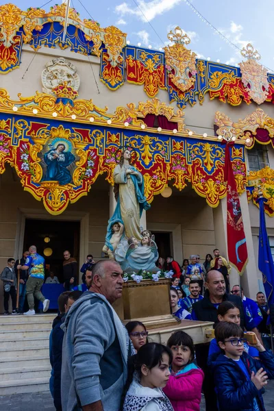 Cospicua, Malta - 1 Aralık 2024. Süslü Dekorasyon ve Katılımcılarla Renkli Dini Festival Yürüyüşü