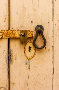 Eski köylü asma kilit ve kilit eskimiş bej tahta kapılı anahtar deliği plakalı.
