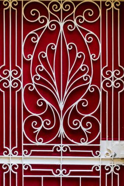 Koyu Kırmızı Arkaplan Mimari Görüntü Dekorasyonuna Karşı Eğri Yazıtlarla Süslemeli Beyaz Demir Kapı