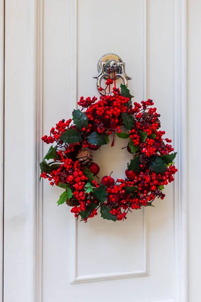 Kırmızı Meyveli Noel Çelengi Ön Kapıda Tatil Süslemesi İçin Beyaz Kapı tokmağında Asılı