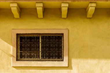 Dekoratif Pencereli Güneşli Sarı Duvar ve Demir Izgara Mimari Aksanı