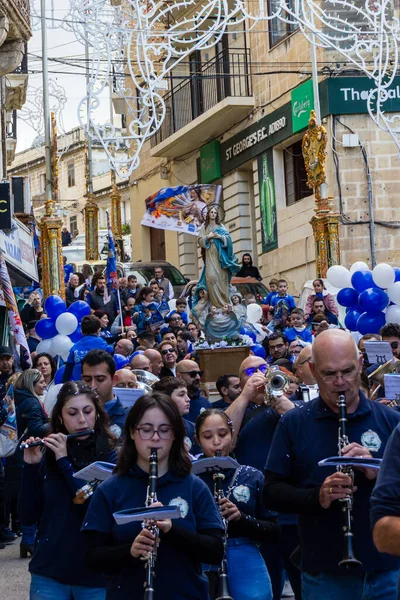 Cospicua, Malta - November 30th, 2025, Religious Festival Procession With Virgin Mary Statue Amid Crowded Street Parade During Festive Celebration