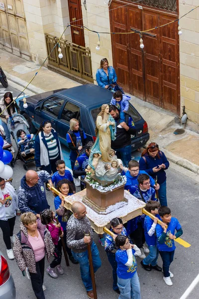 Cospicua, Malta - November 30th, 2025, Religious Festival Procession With Virgin Mary Statue Amid Crowded Street Parade During Festive Celebration