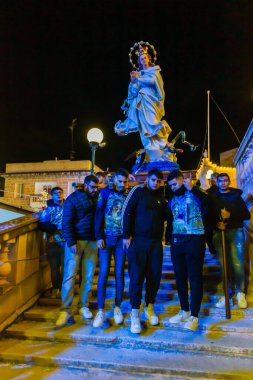 Cospicua, Malta - 6 Aralık 2025, Dindar Taşıyıcılar tarafından çevrelenmiş Bakire Meryem Heykeli ile Gece Dini Töreni