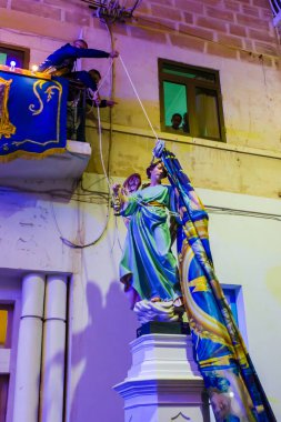 Cospicua, Malta - 6 Aralık 2025, Gece Geçidi Festivali sırasında balkon manzaralı Renkli Melek Heykeli