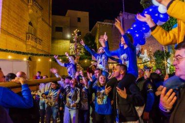 Cospicua, Malta - 6 Aralık 2025, Neon-Lit Caddesi boyunca Mavi ve Beyaz Balonlarla Gece Festivali Geçidi