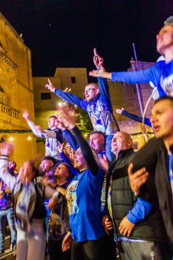 Cospicua, Malta - 6 Aralık 2025, Neon-Lit Caddesi boyunca Mavi ve Beyaz Balonlarla Gece Festivali Geçidi
