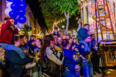 Cospicua, Malta - 6 Aralık 2025, Neon-Lit Caddesi boyunca Mavi ve Beyaz Balonlarla Gece Festivali Geçidi