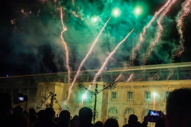 Cospicua, Malta - 7 Aralık 2025, Kalabalık Tezahürat ve Şehir Parıltısı ile Renkli Gece Havai fişekleri