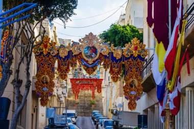 Cospicua, Malta - 8 Aralık 2025, Süslü Akdeniz Caddesi Üzerinde Tarihi Binalar ve Bayraklarla Festival Kemeri