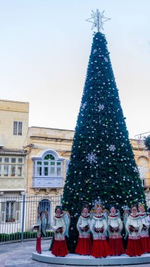 Büyük açık hava Noel Ağacı, tarihi binaların önündeki süslerle ve kar taneleriyle süslenir.