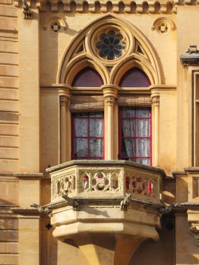 Kırmızı Çerçeveli Güneş Işıklı Sarı Taş Bina 'da Tarihi Gotik Pencere Balkonu