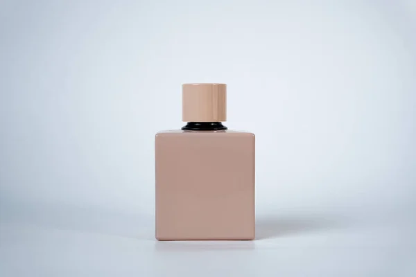 Tarafsız arka planda siyah kapaklı şık bej parfüm şişesi reklamcılık için minimalist parfüm tasarımı. 