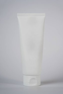 Açık gri arka planda duran temiz kozmetik tüpü. Asgari cilt bakımı ve ambalaj kavramı. 
