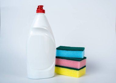 Temiz bir arka planda renkli süngerlerle dolu beyaz temizlik deterjanı şişesi. Temizlik ürünü reklamcılığı, ev bakımı veya hijyen tasarım projeleri için ideal. 