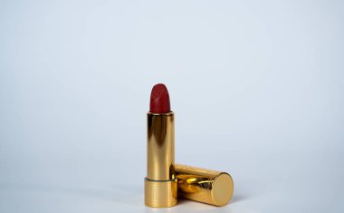 Kırmızı rujlu, yanında şapkası olan şık, minimalist bir fotoğraf. Güzellik, kozmetik veya moda pazarlaması için ideal, zarafet, güven ve kaliteli kadınlığı temsil ediyor. 