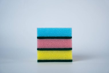 Beyaz arka planda izole edilmiş renkli mutfak süngeri yığını. Reklam temizlik ürünleri, ev işleri ve parlak modern tasarımı olan hijyen kavramları için harika.. 